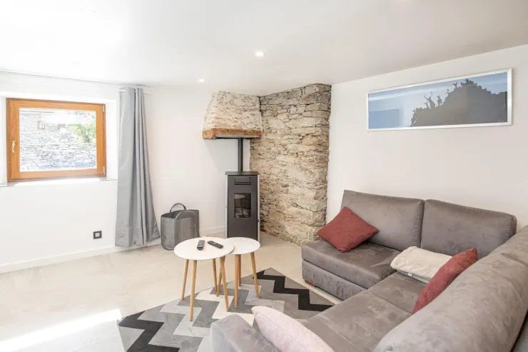 Coin salon avec banquette , TV, poële à bois