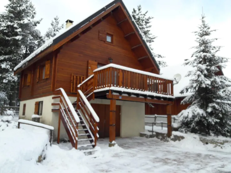 Vue du chalet (hiver) avec 2 places privatives - accès direct par porte garage pour espace dépôt matériels de skis, etc... ou  par escalier vers terrasse - parcelle clôturée avec accès direct dans la forêt par portillon derrière le chalet