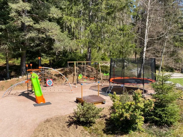 Playground with trampoline, swing, sandbox, slide, archery