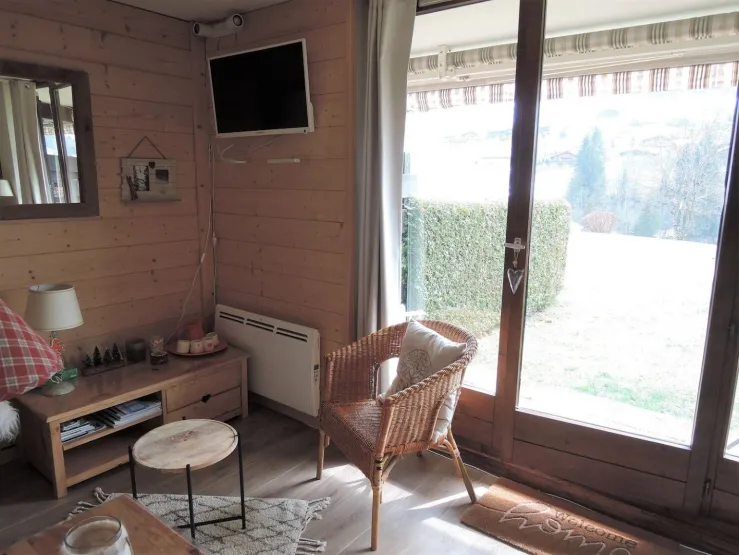 Séjour télévision avec vue sur la terrasse et le jardin.
