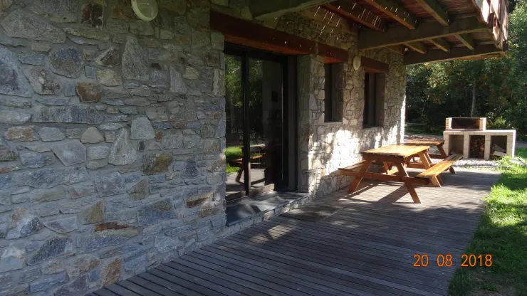 Terrasse du RdC avec 2 tables pique-nique et un grand barbecue.