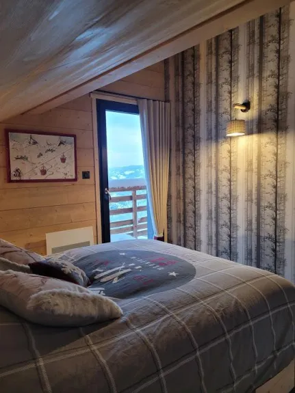 chambre étage Les Marmottes 8m2 : lit 140x200 ,penderie , coffre , deux tiroirs dans le lit , literie super confort , porte fenêtre sur balcon avec vue sur les montagnes, plein sud  .
