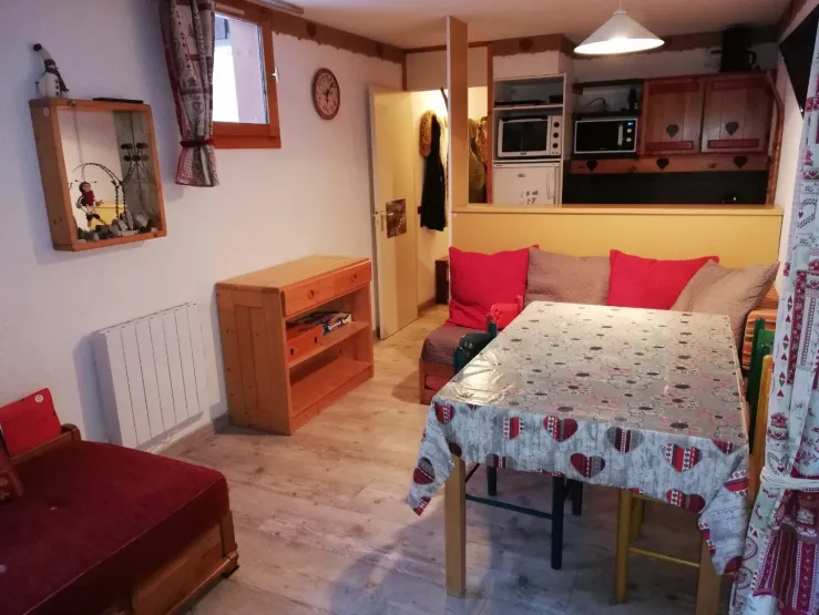 Cuisine équipée avec plaque de cuisson induction, lave vaisselle, frigo, four et bar de séparation.