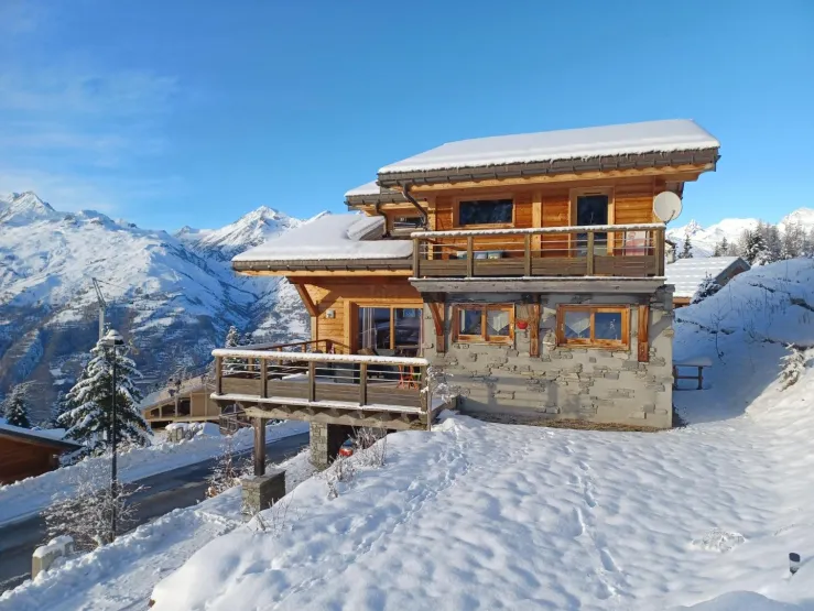 Entrée sous la terrasse avec hall dressing et stockage ski, 2 places de parking abritée sous la terrasse.