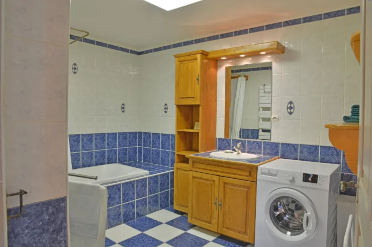 Salle de Bains avec baignoire utilisable en douche(inadapté pour les personnes âgées), lavabo et machine à laver le linge.