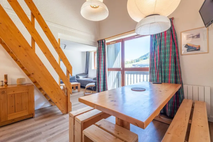 Main living area and the balcony with direct view on ski slopes (winter) / tennis courts (summer)