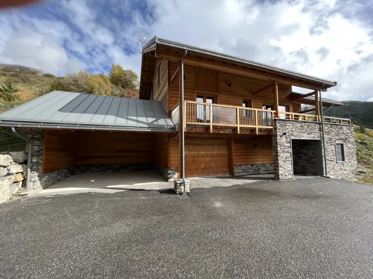 Vue façade Ouest :
De gauche à droite :
    - Abri voitures 2 places.
    - Garage sécurisé 1 place.
    - Entrée du chalet sous le porche.