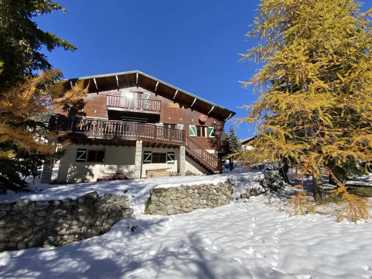 Le chalet, façade sud entourée de mélèzes sous les premières neiges de novembre.