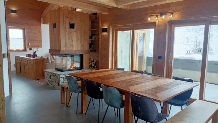 Salle à manger ouverte sur l'extérieur, la cheminée et sur la cuisine