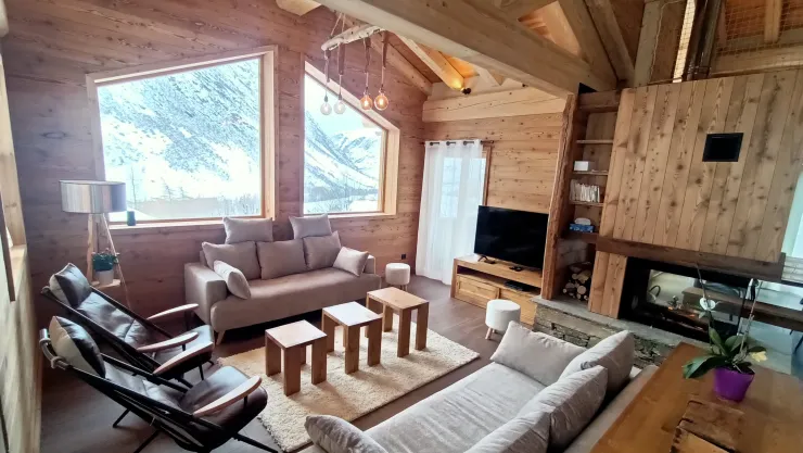Salon, lumineux avec ses grandes ouvertures et à la fois chaleureux avec la charpente apparente et la cheminée. Superbe vue dégagée. 