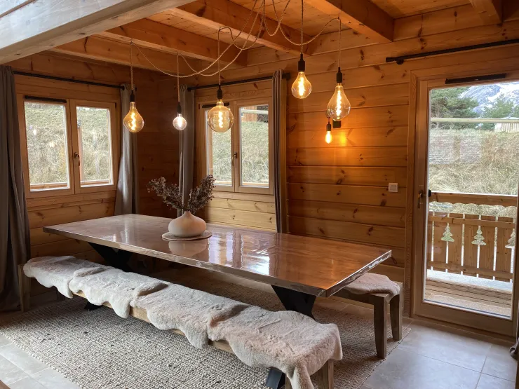L'espace repas très cosy est occupé par une grande table en teck et de grands bancs habillés de chaudes peaux (chaises et tabourets en plus si nécessaire)