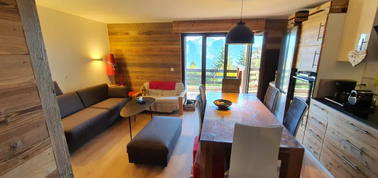 Pièce principale vue depuis l'entrée, avec cuisine équipée, coin salon et donnant accès à un grand balcon terrasse de 18 m2.