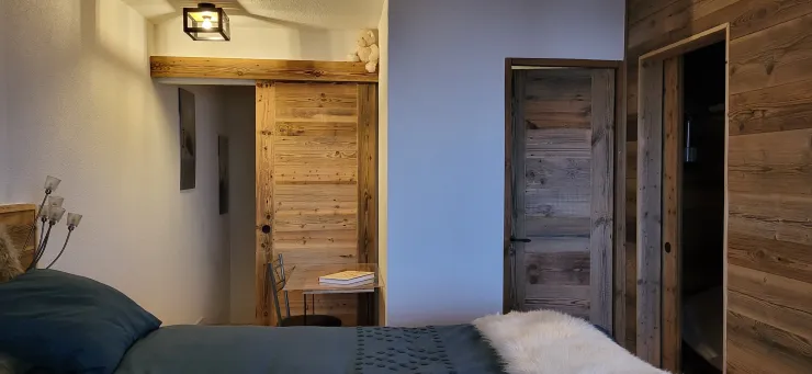 Chambre à l'étage avec une petite chambre cabine (à droite sur la photo), une salle de douche (douche, vasque, WC) et l'accès aux escaliers qui descendent.