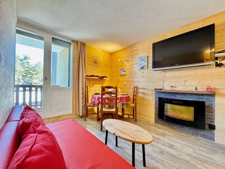 Living room view with dining table, coffee table, large TV and electric fireplace