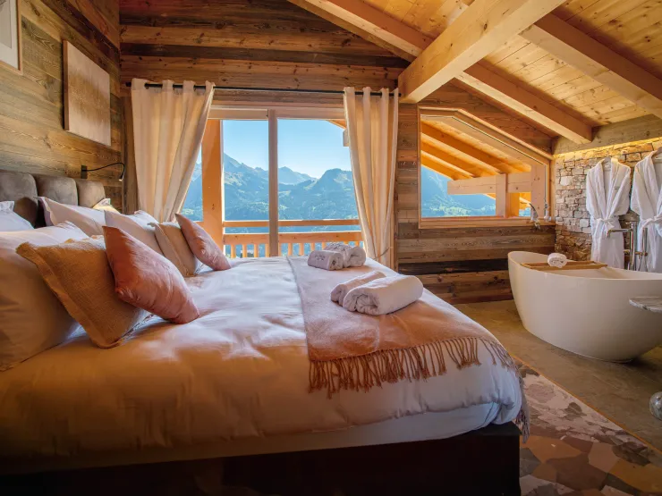 Elegant master suite with a bathtub and breathtaking mountain views. A luxurious haven designed for pure relaxation.