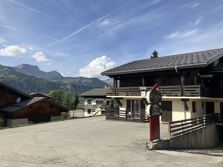 Vue en avant plan du parking devant la Résidence réservé aux locataires; en arrière plan vue sur la chaîne des Aravis.
