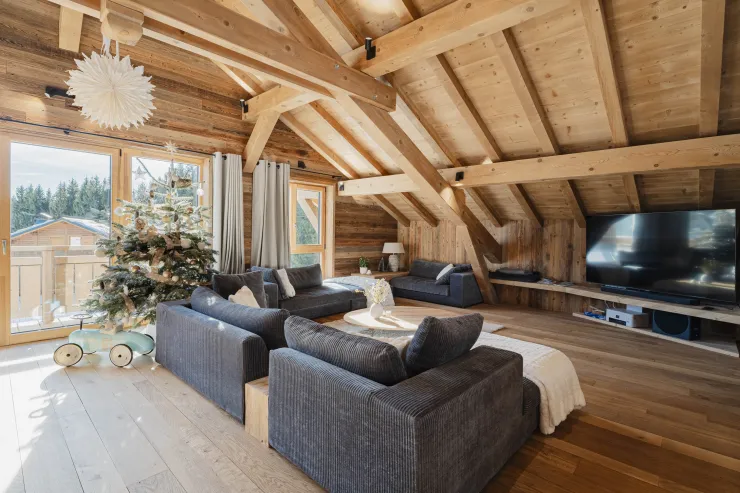 Living area with spacious sofas and a large connected flat-screen OLED TV