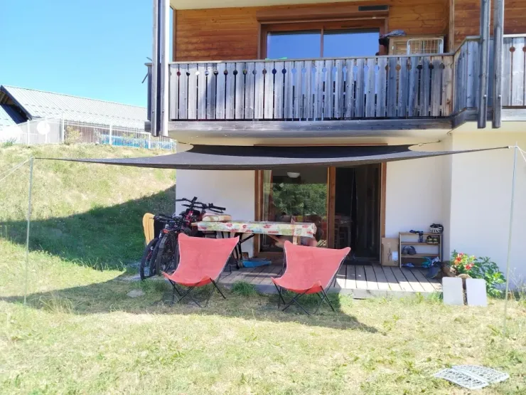 Vue sur la terrasse en rez de jardin avec la piscine en ahut à gauche ouverte juillet-août de 10h à 19h