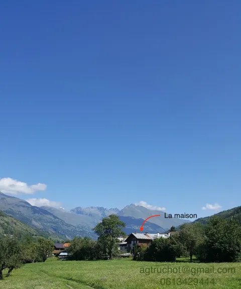 maison en été vue depuis le champ
