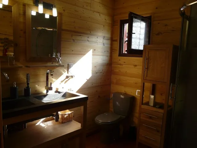 La salle de bain est équipée d'un meuble en chêne double vasques en pierre naturelle avec rangement et d'un meuble colonne à tiroirs assorti. Un sèche-cheveux et un lisseur sont à votre disposition.