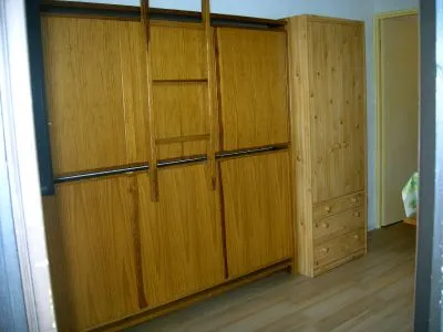 2 lits superposés repliables contre le mur + armoire de rangement dans le fond de la pièce