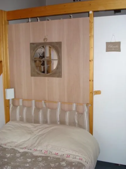 View of the second bedroom, upstairs the living room, including a 2 places bed, a desk, and a flat-screen TV.