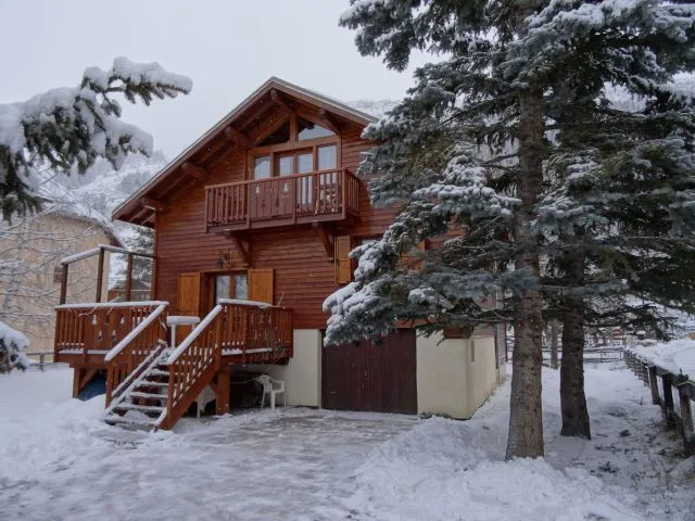 Chalet enneigé hiver avec mélèzes 