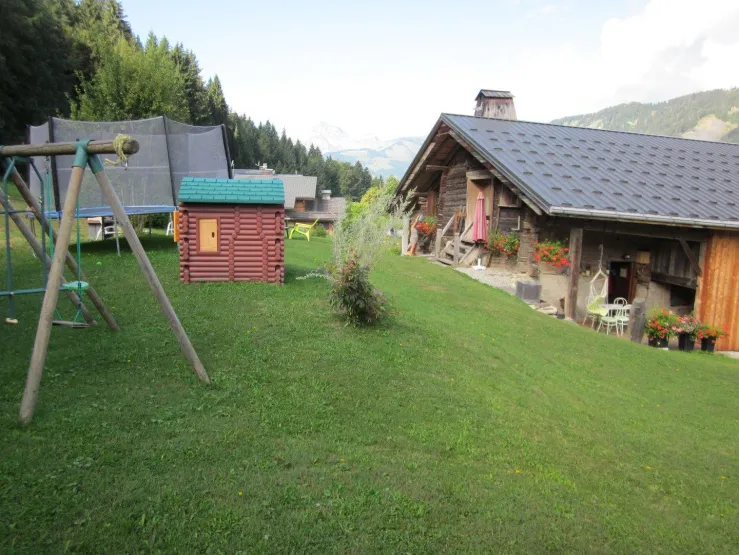 le chalet en été , avec trampoline , balançoire, cabane