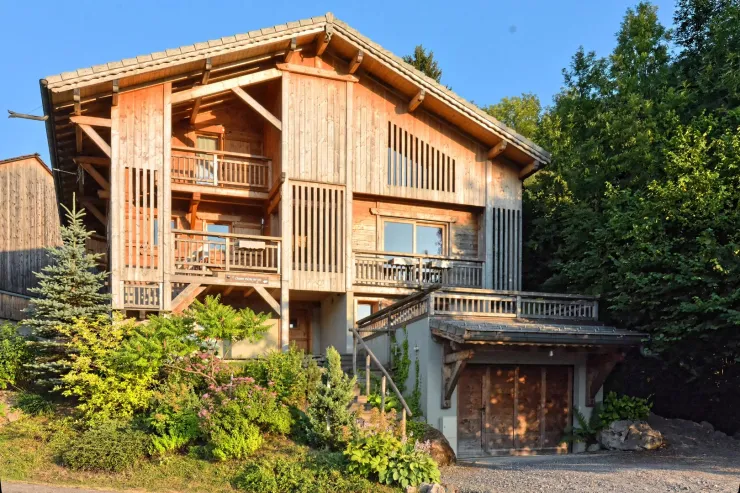 The chalet in summer at the sunset. View of the 3 levels of the chalet and the garage which contain an electric ski-boots dryer.