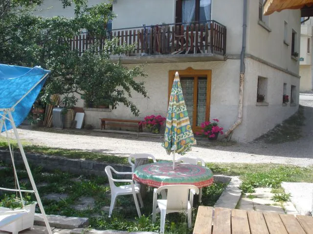 Facade exterieur porte du côté jardin avec salon de jardin pour l'été