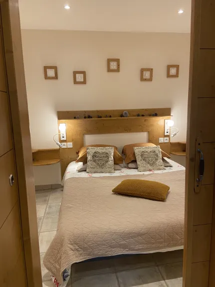 chambre de la location Casareva avec lit double 160 cm de large agencée avec double éclairage de chaque côté de la tête de lit, chevet + porte coulissante