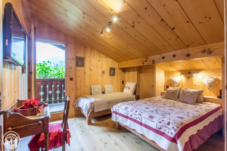 grande chambre avec balcon vue sur la chaine du mt blanc literie tout confort  écrans plat petite table et chaise lit fait 