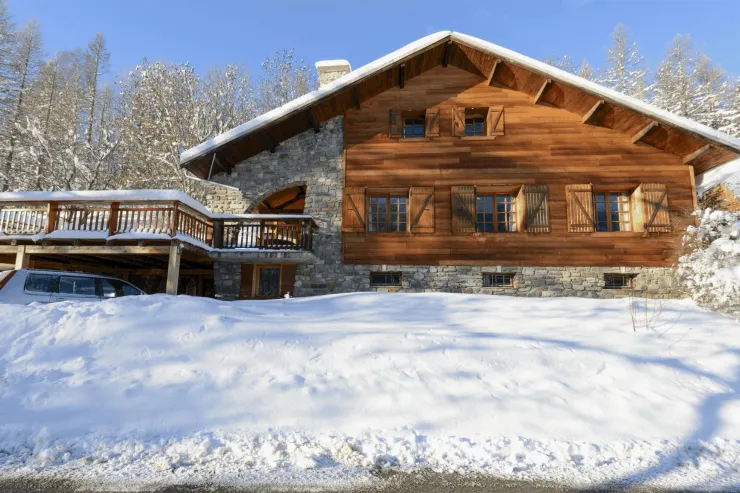 Front view of chalet with 3 cars parking area under terrace