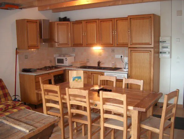 le cuisine, tout équipée et meublée en bois, donne sur le séjour et l'accès par la porte-fenêtre du balcon 