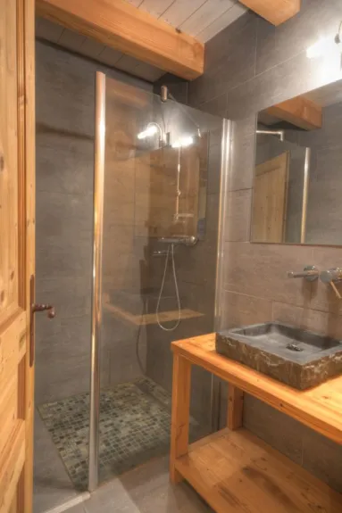 Un salle de douche privative dans une chambre. Toutes les salles de douche ont une décoration soignée similaire.