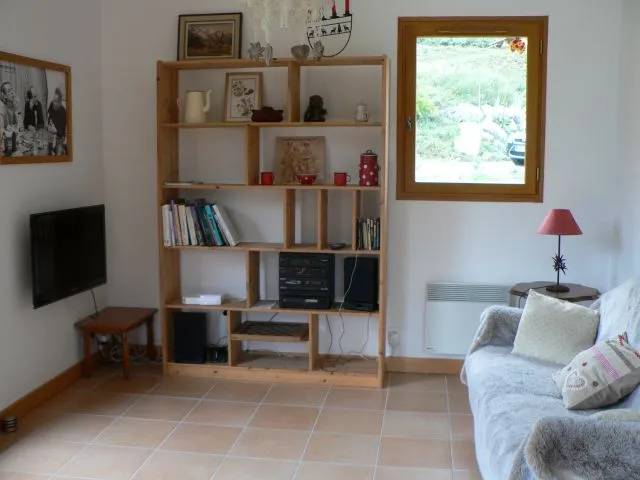 Living room : TV , music and bibliothèque area. Baie window on west Terrace and window with  north view.