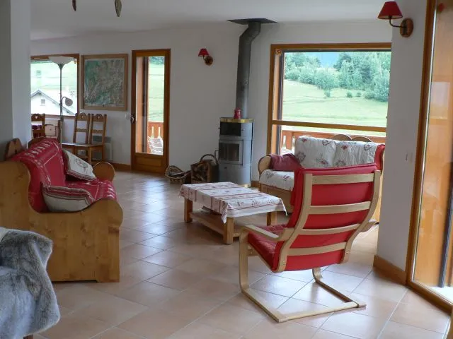 Living room, with " stove area  " .Larges south baies windows.  Access to the south balcony  and to west terrace. 
