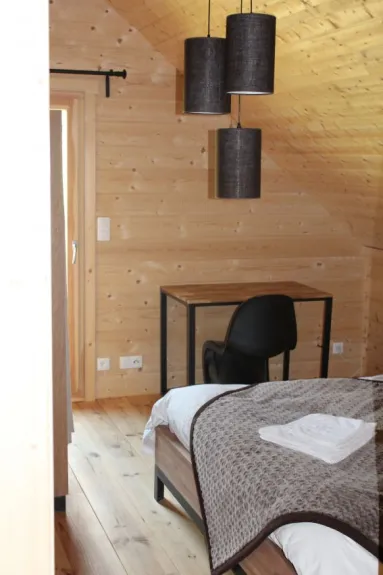 Chambre parentale avec un lit de 160/200, une armoire, un bureau, cette chambre donne sur un balcon