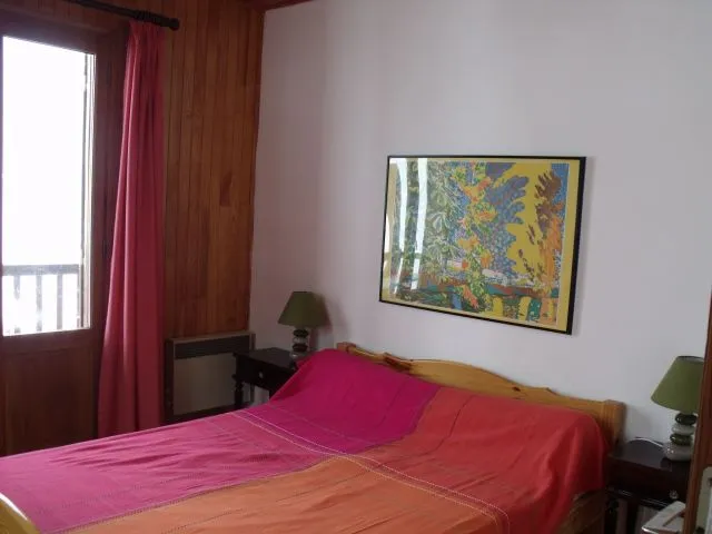  Chambre avec un balcon où se trouve une petite table ou l'on peut boire un café où déjeuner pour trois ou quatre personnes. dans la chambre un placard avec des couvertures. Une autre fenêtre.