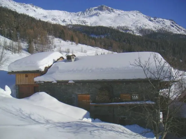 Ski slopes of Sainte-Foy are visible behind the chalet.