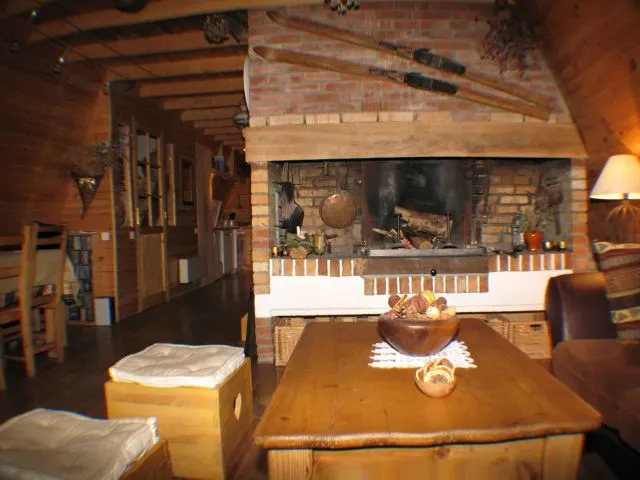 Salon avec grande cheminée, à gauche salle à manger et au fond  vous appercevez la  cuisine