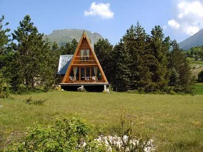 Vue d'ensemble du chalet et de son jardin en été