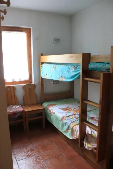 chambre enfants avec lits à étage, placard de rangement. Fenêtre ouvrante qui donne sur le parking 