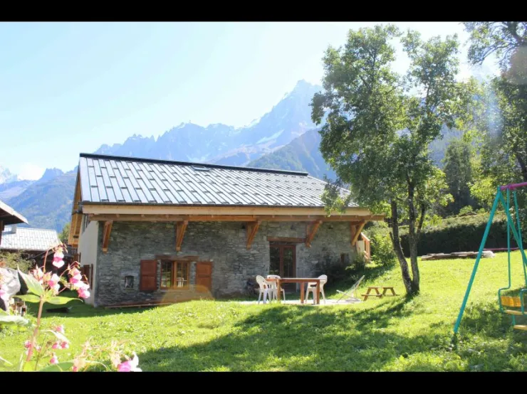 En été, portique , jardin privatif, tables de jardin et vue sur les aiguilles de Chamonix.
