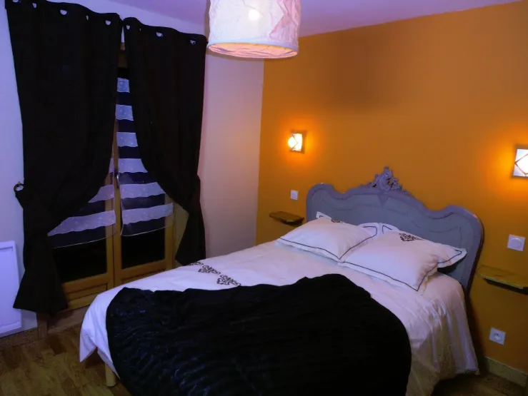 Chambre 1 avec lit double 140 et porte fenêtre sur le balcon à l'avant du chalet
