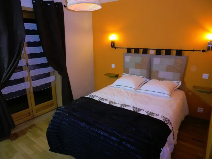 Chambre 2 avec lit double 140 et porte fenêtre sur le balcon à l'avant du chalet