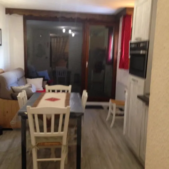 Vue sur la pièce à vivre avec table 6 chaises le lit 2 pers (rapido) et porte fenêtre donnant sur le balcon avec volet roulant electrique 