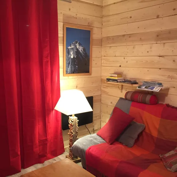 Un salon chaleureux avec un clic clac, TV, Wifi