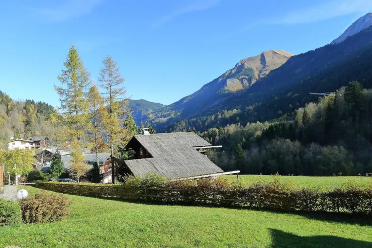 Le val Montjoie : le chalet dans son site face à la montagne : l'aiguille de Bionnassay  ( 4052 m ) , les dômes de Miage  ( 3675 m ) et l'aiguille de la Bérangère ( 3425 m ) . Devant le chalet :  très grande prairie de fauche qui descend jusqu'au Bon Nant