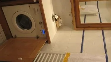 Salle de bain avec lave linge sèche linge
